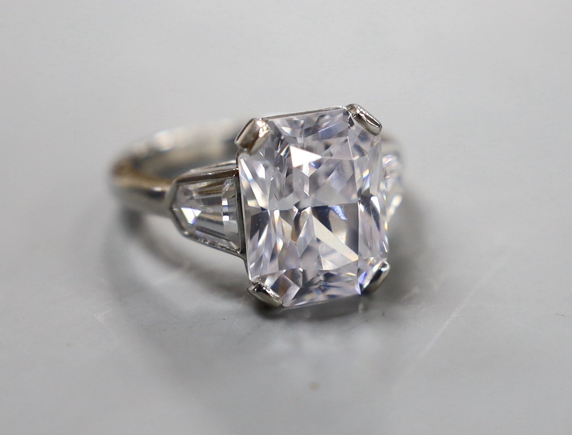 A white metal (stamped Plat) and fancy cut singe stone cubic zirconia set dress ring, with cubic zirconia set shoulders, size O, gross weight 9.7 grams.
